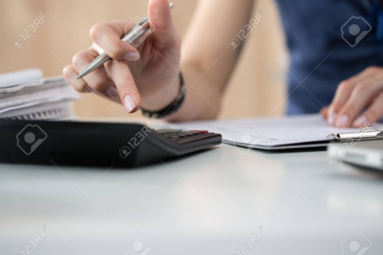 Close up of female accountant or banker making calculations. Savings, finances and economy concept - 46009349 Close up of female accountant or banker making calculations. Savings, finances and economy concept - 46009349
