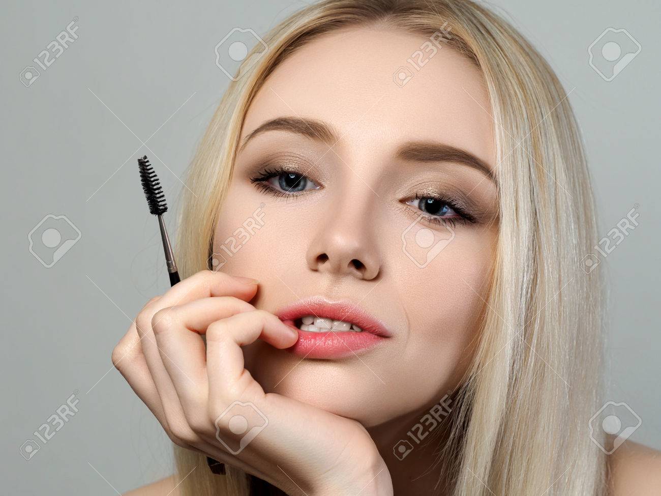 若い思慮深い金髪美人鏡を見て 眉ブラシを保持しています 化粧品 美容師 メイクの間違いの概念 の写真素材 画像素材 Image