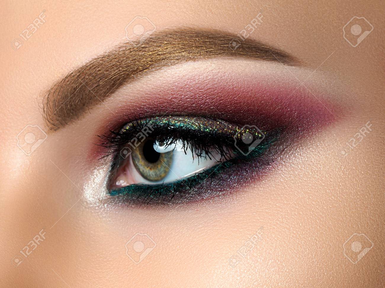 close up of beautiful woman eye with multicolored smokey eyes..