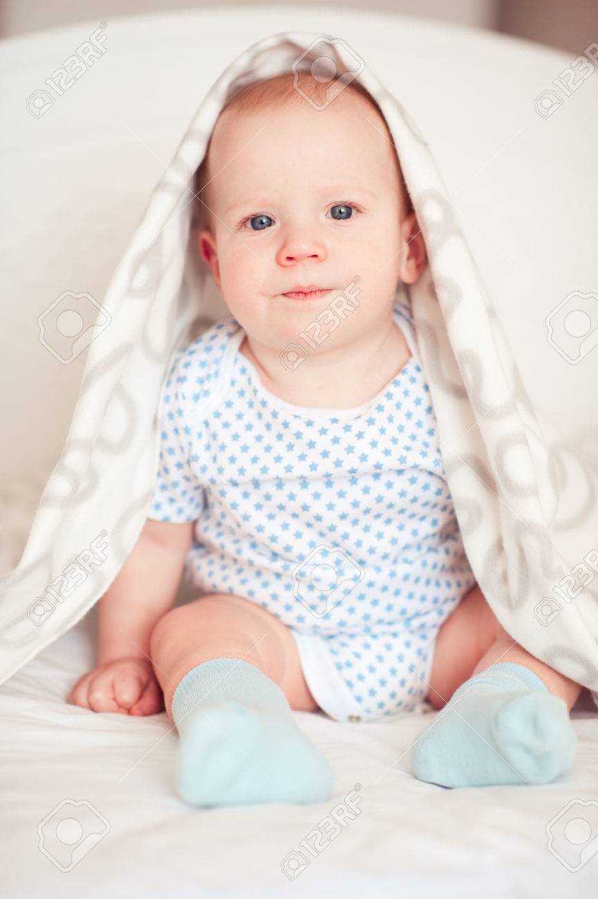 面白い赤ちゃん男の子の部屋でベッドに座っています カメラを見ています 子供の頃 の写真素材 画像素材 Image