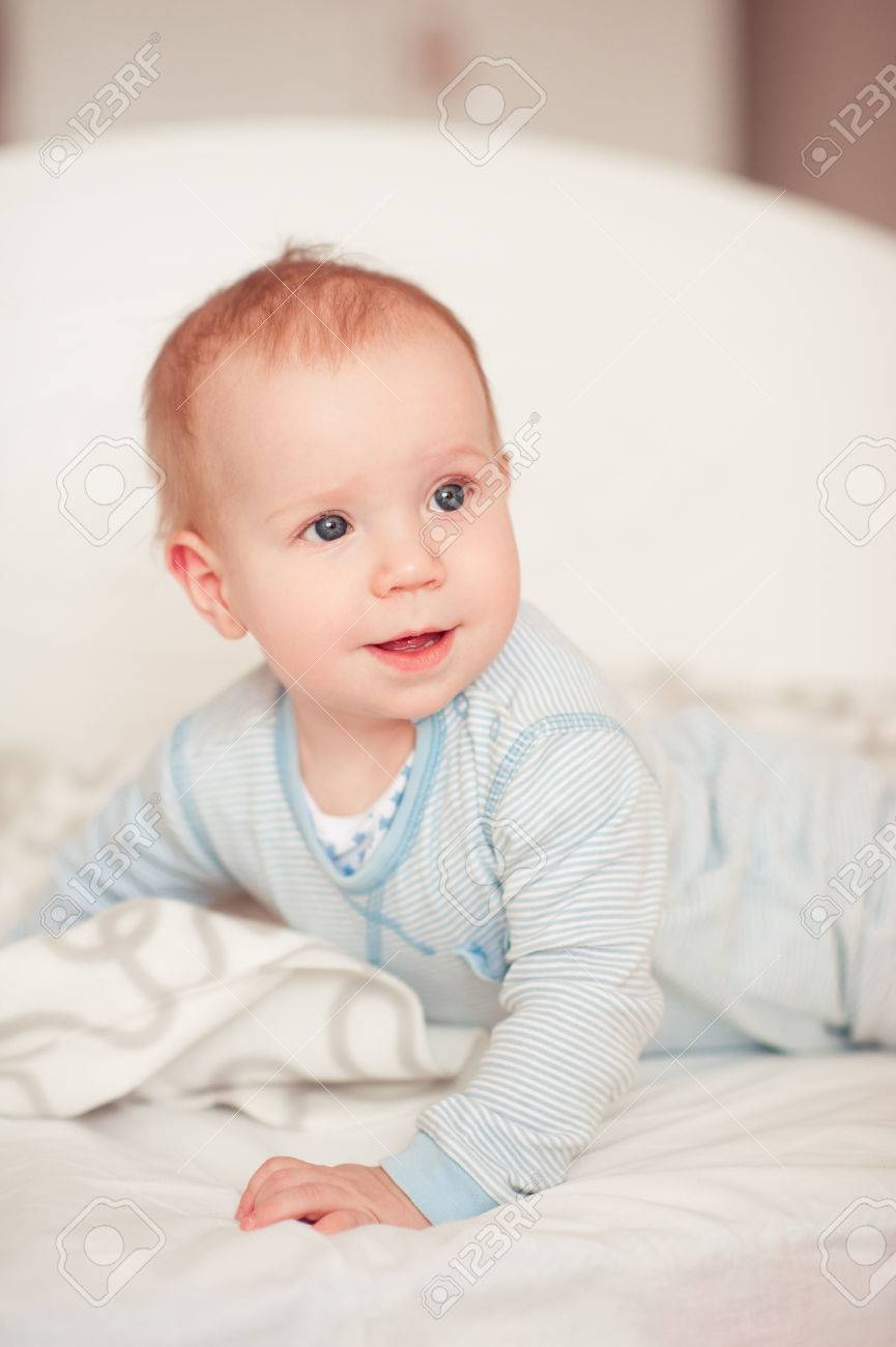 Smiling Baby Boy Wake Up In Bed In Room Wearing Pajamas Looking