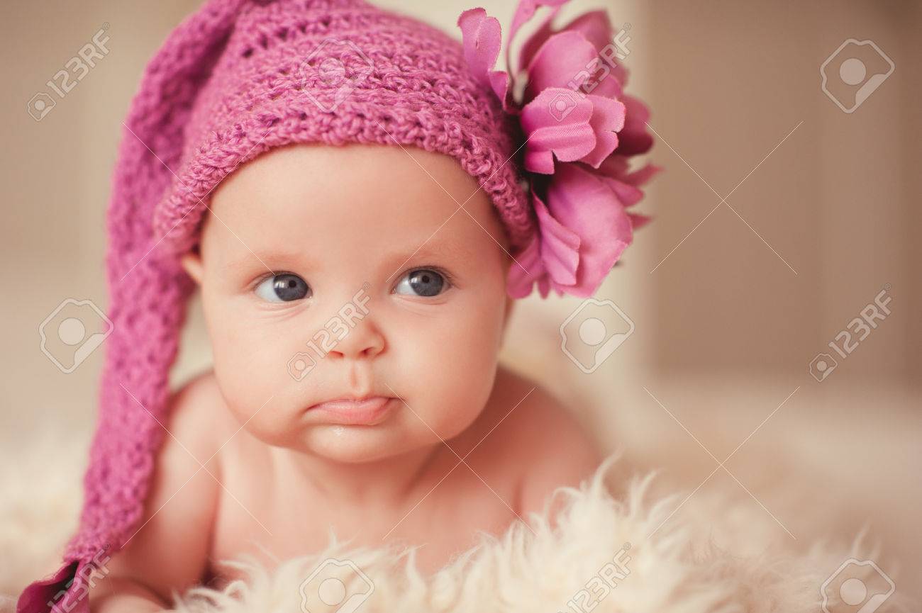 Bebe Drole Mignon 2 3 Mois Portant Le Chapeau Tricote Rose Avec La Fleur Couchee Dans Son Lit Regarder Ailleurs Enfance Banque D Images Et Photos Libres De Droits Image