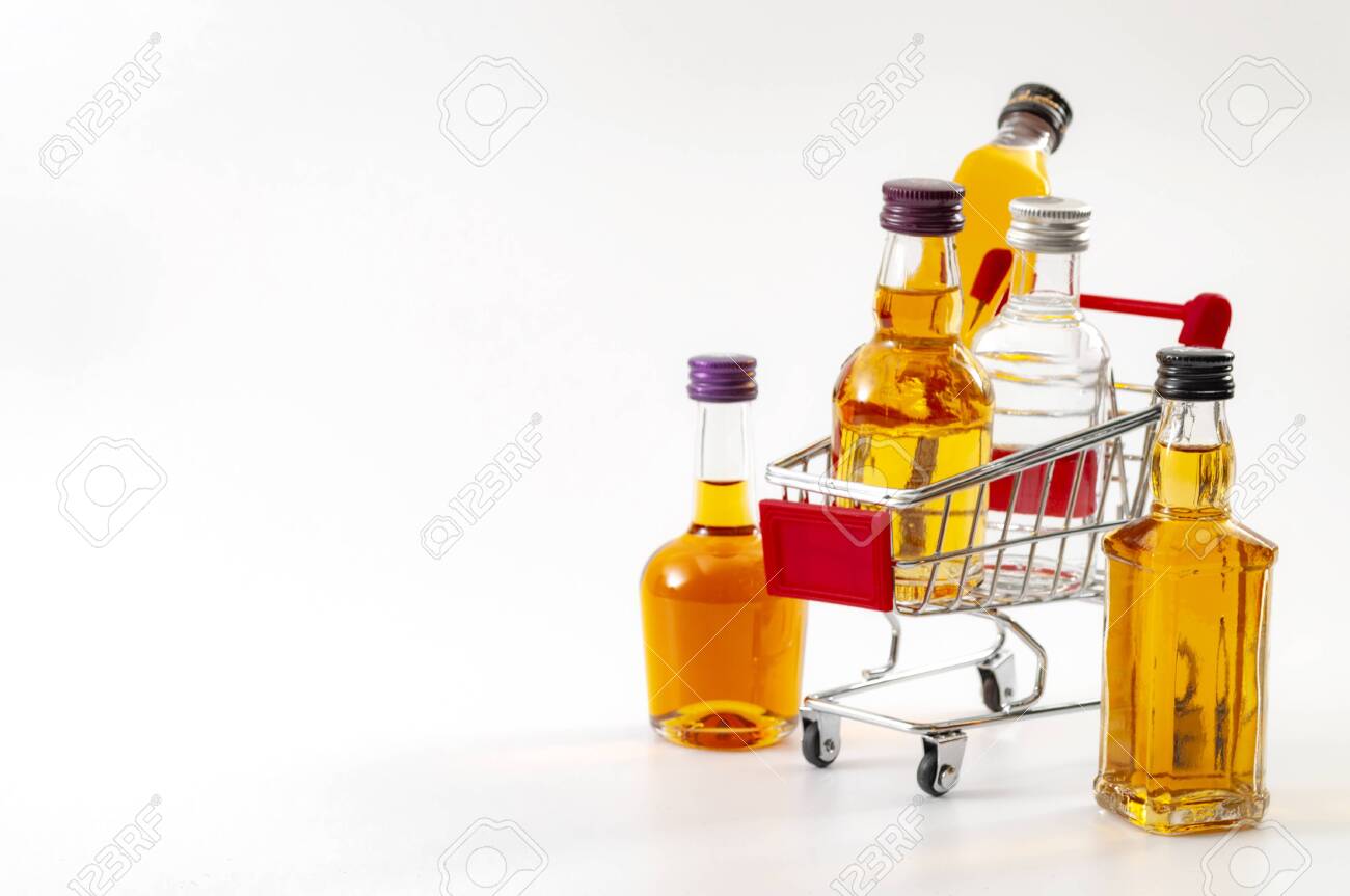 Buy booze, shopping the liqueur aisle and purchase of alcoholic beverages concept theme with mini bottles of alcohol in a small supermarket cart isolated on white background with copy space - 152400751 Buy booze, shopping the liqueur aisle and purchase of alcoholic beverages concept theme with mini bottles of alcohol in a small supermarket cart isolated on white background with copy space - 152400751