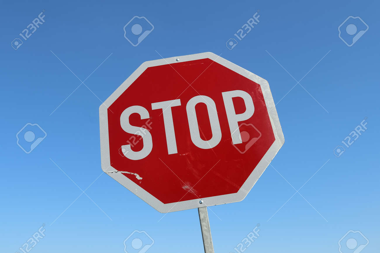 Close up of a stop sign against a clear blue sky - 169911836 Close up of a stop sign against a clear blue sky - 169911836