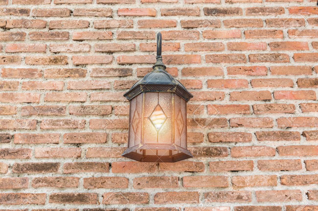 exterior vintage wall lamp illuminated on brick wall building stock