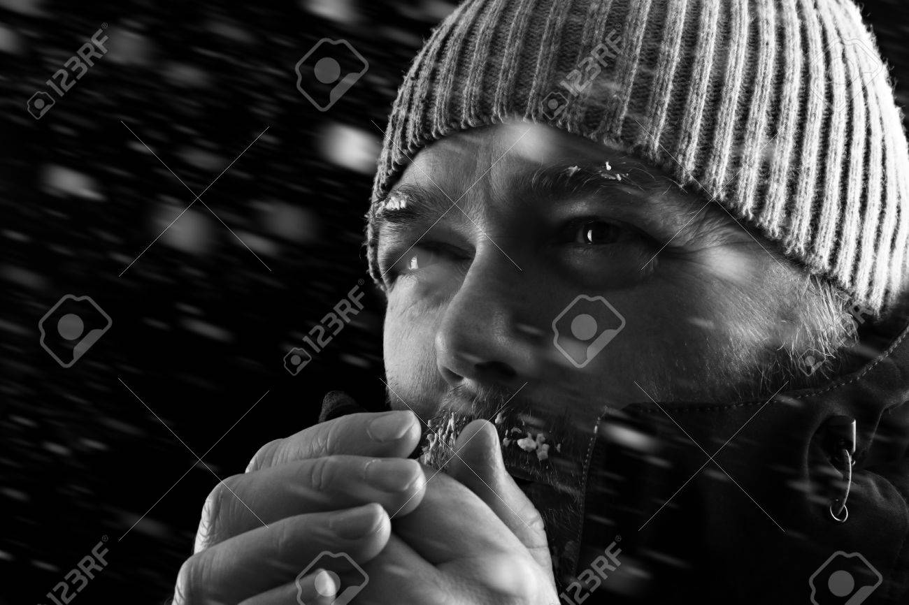 凍結の冷たい男保温しようとして雪の嵐 Biazzard に立っています 霜と氷の彼のひげと眉毛でビーニー帽子 冬のコートを着ています 黒と白 の写真素材 画像素材 Image