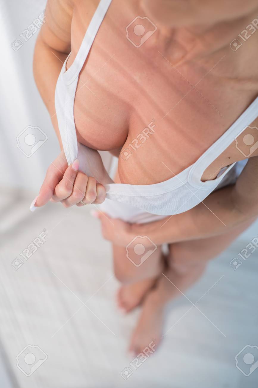 Mulher Sexy Mostra Seus Grandes Seios De Silicone, Puxando Seu Top Branco  Com As Mãos Em Um Fundo Branco. Belos Seios Elásticos Forma Perfeita Foto  Royalty Free, Gravuras, Imagens e Banco de