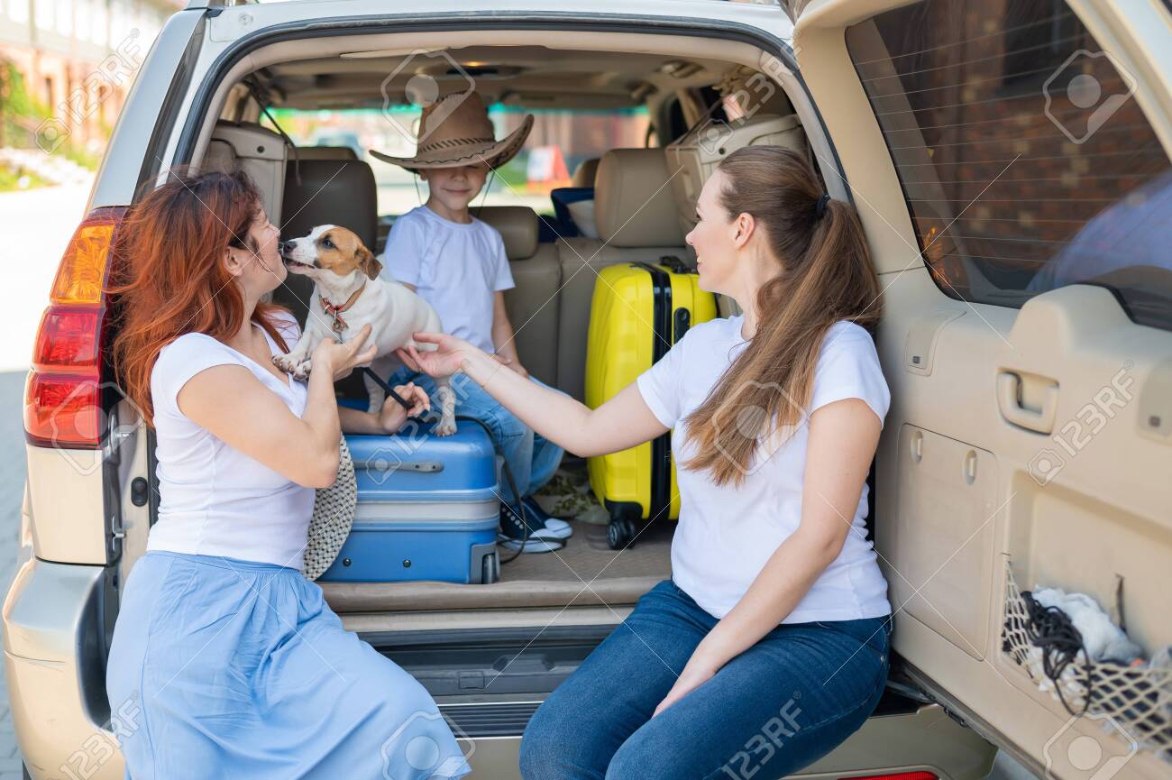 Happy Same-sex Family Going On A Car Trip Around The Country. Lesbian  Couple With Son And Dog Are Loading Luggage In The Trunk And Is Ready For  Summer Vacation. Independent Travel. Фотография,