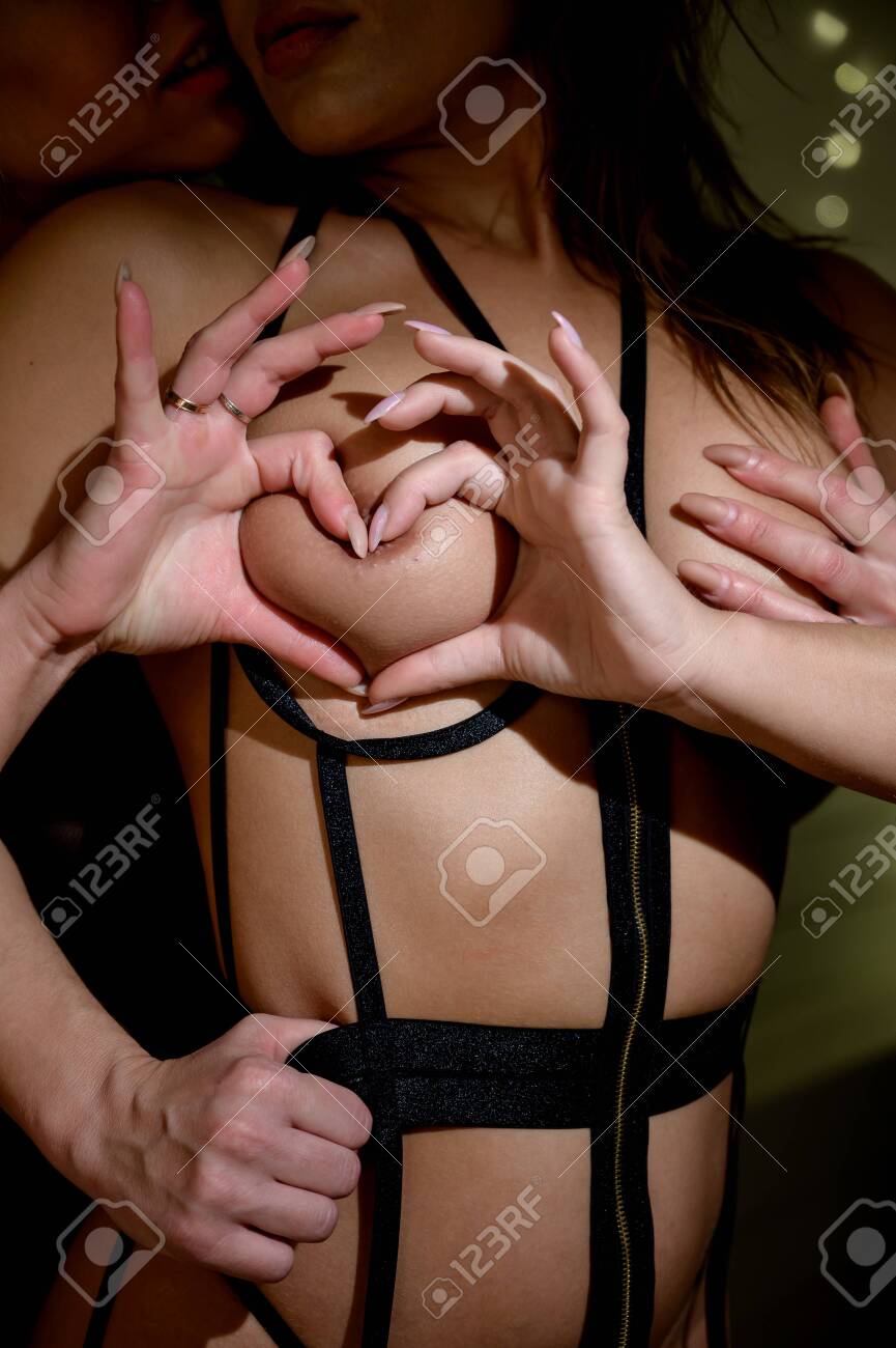 Happy Valentines Day. Two Lesbians Show Love. A Woman Hugs A Partner From  The Back And Caresses Her Boobs. Heart Sign With Hands. Stock Photo,  Picture and Royalty Free Image. Image 152644503.