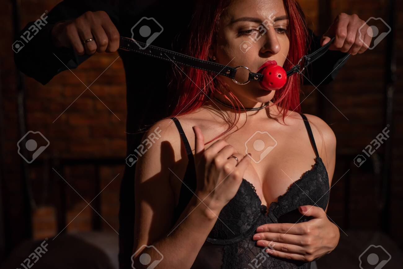 Immagini Stock - Un Uomo Domina E Mette Un Bavaglio In Bocca Al Suo  Partner. Concetto Di BDSM. Ritratto Di Una Donna In Biancheria Intima  Seducente Con Un Giocattolo Intimo In Bocca.