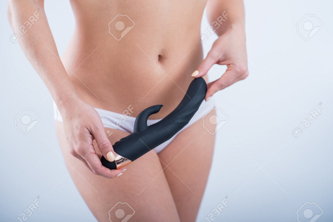 ディルドパンテイ 白い綿のパンティーの顔のない女性は、白い背景に黒いディルドを持っています。オナニー用女性バイブの写真素材・画像素材 Image 161641503
