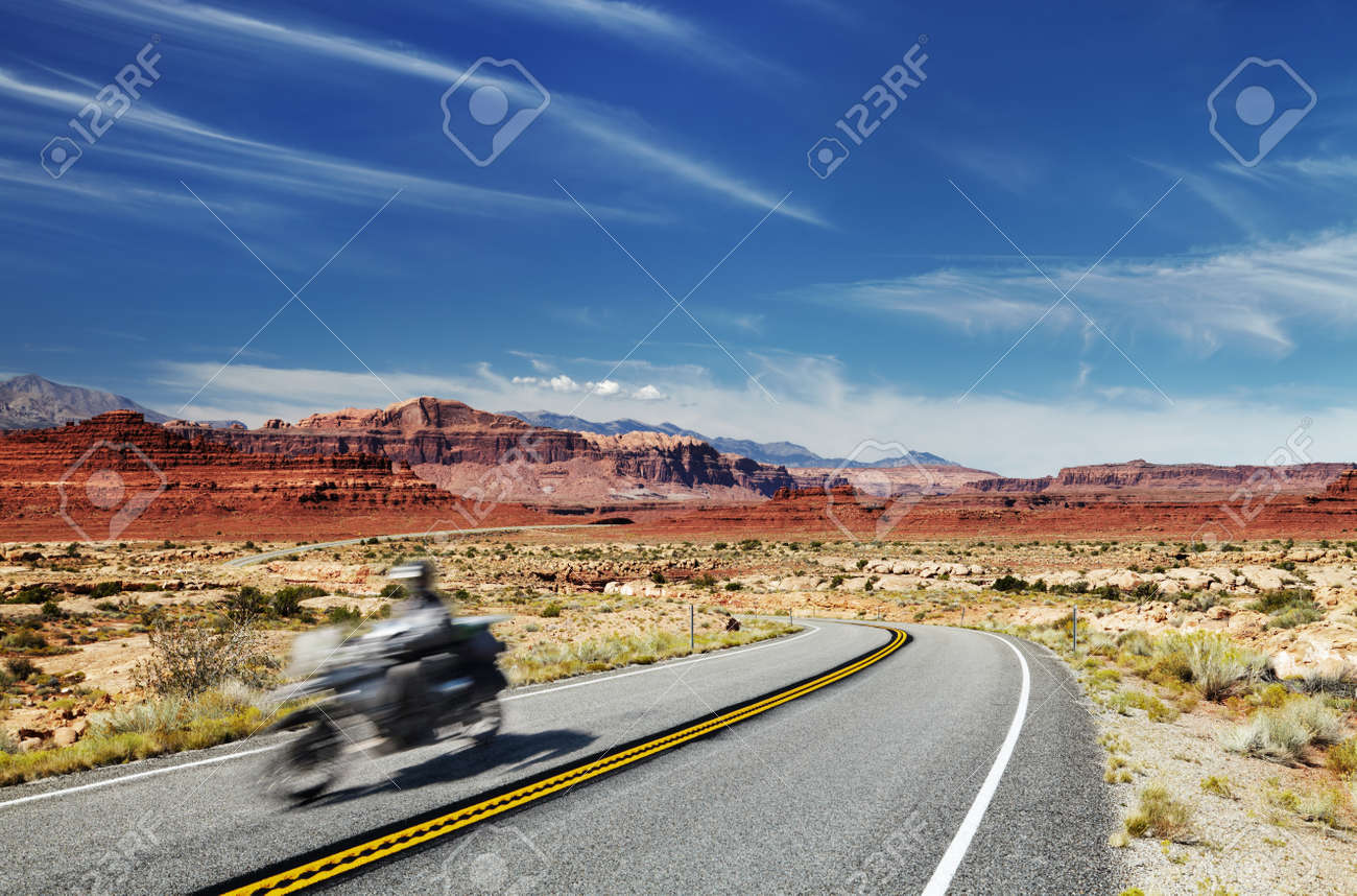 Motorcycle traveler riding in American highway, Glen Canyon, Utah, USA. Main object in motion blur - 165228560 Motorcycle traveler riding in American highway, Glen Canyon, Utah, USA. Main object in motion blur - 165228560