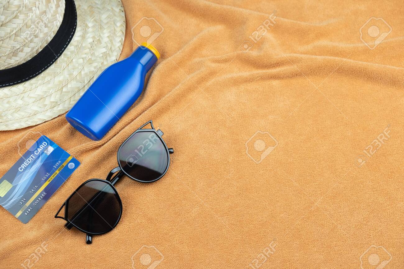Top view of beach background. eyeglasses and credit card and sunscreen lotion and woven hats, trevel summer concept - 133765191 Top view of beach background. eyeglasses and credit card and sunscreen lotion and woven hats, trevel summer concept - 133765191
