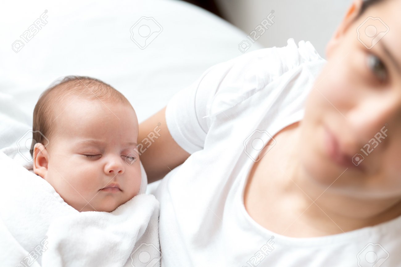 close-up portrait of mom with newborn baby on white background copy space. Young cute caucasian woman black haired holding child in arms motherhood, infancy, childhood, family, Mothers day concept - 164686182 close-up portrait of mom with newborn baby on white background copy space. Young cute caucasian woman black haired holding child in arms motherhood, infancy, childhood, family, Mothers day concept - 164686182