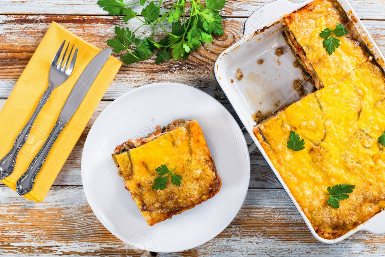 Teil Der Köstlichen Moussaka Auf Teller Mit Messer Und Gabel Und In ... Teil Der Köstlichen Moussaka Auf Teller Mit Messer Und Gabel Und In ...