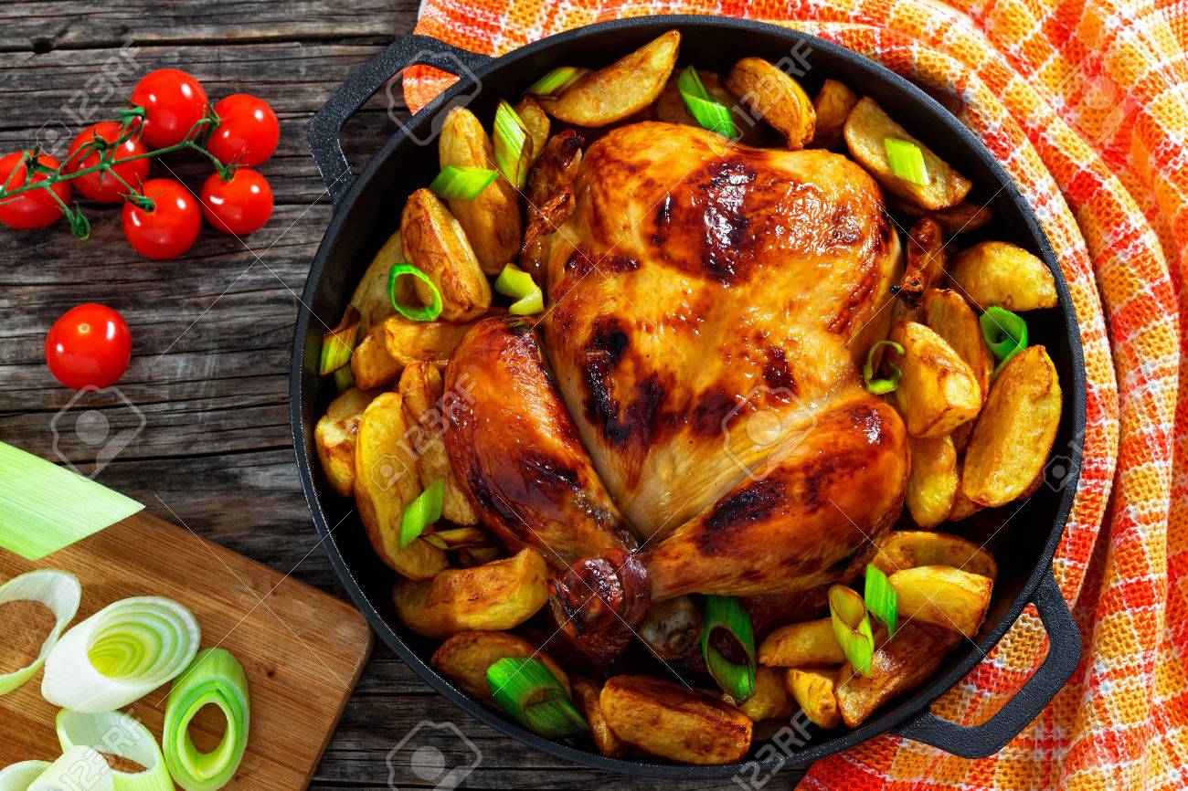 Poulet Doré à La Peau Croustillante Grillé Au Four Avec Des Quartiers De Pommes De Terre Et Des Poireaux Dans Une Poêle En Fonte Sur De Vieilles
