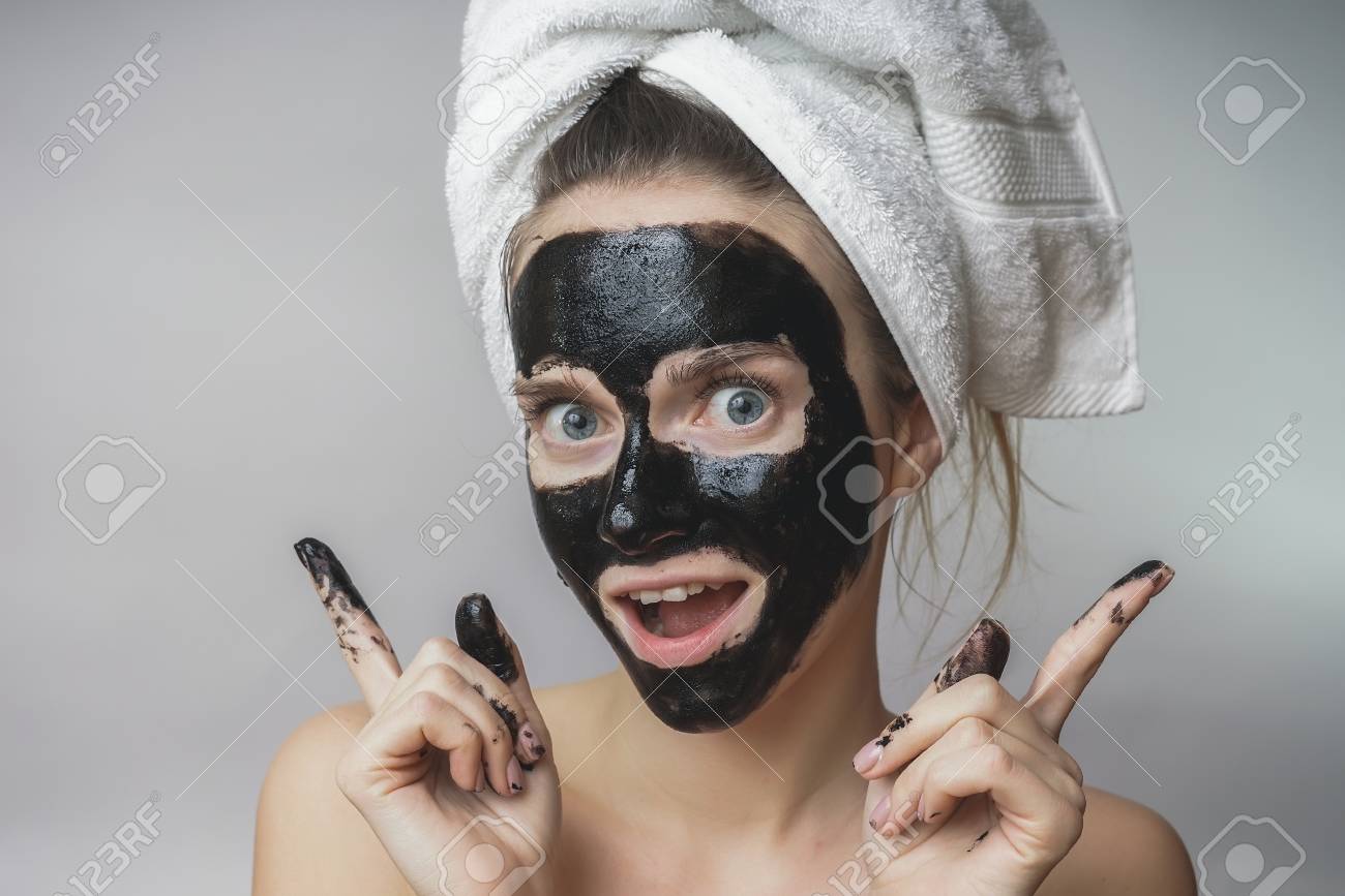 笑ってうれしそうな女性の顔に黒いマスクを取得します 皮膚の剥離 きれいな毛穴ケア の写真素材 画像素材 Image