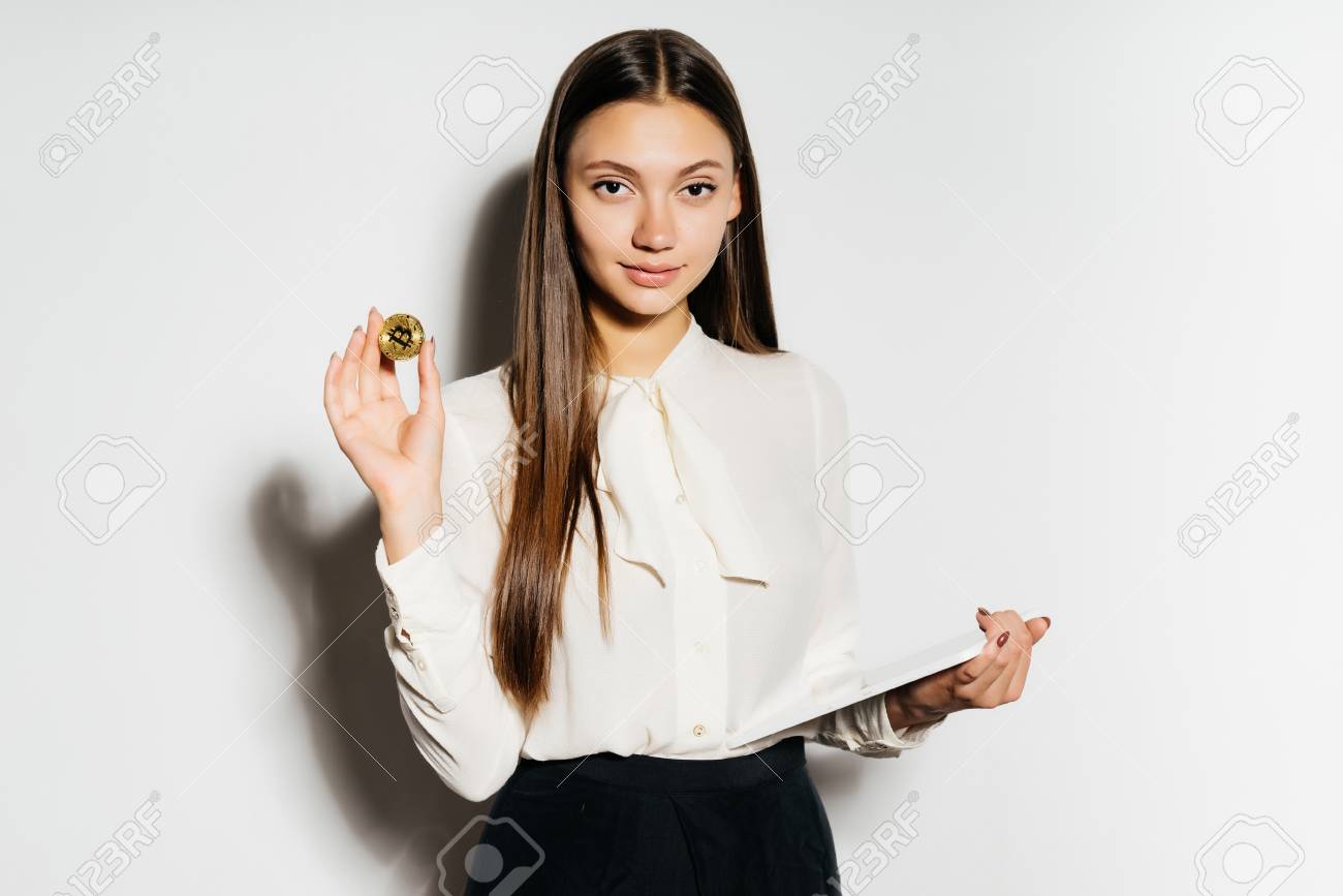 A Young Confident Business Lady Is Studying Crypto Currency, Is Holding A  Gold Bitcoin And A Tablet In Her Hand Stock Photo, Picture and Royalty Free  Image. Image 88133376.
