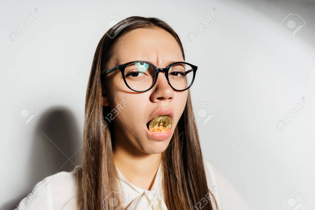 メガネの女の子は彼女の口に大型コインを保持します。の写真素材・画像素材 Image 88765808