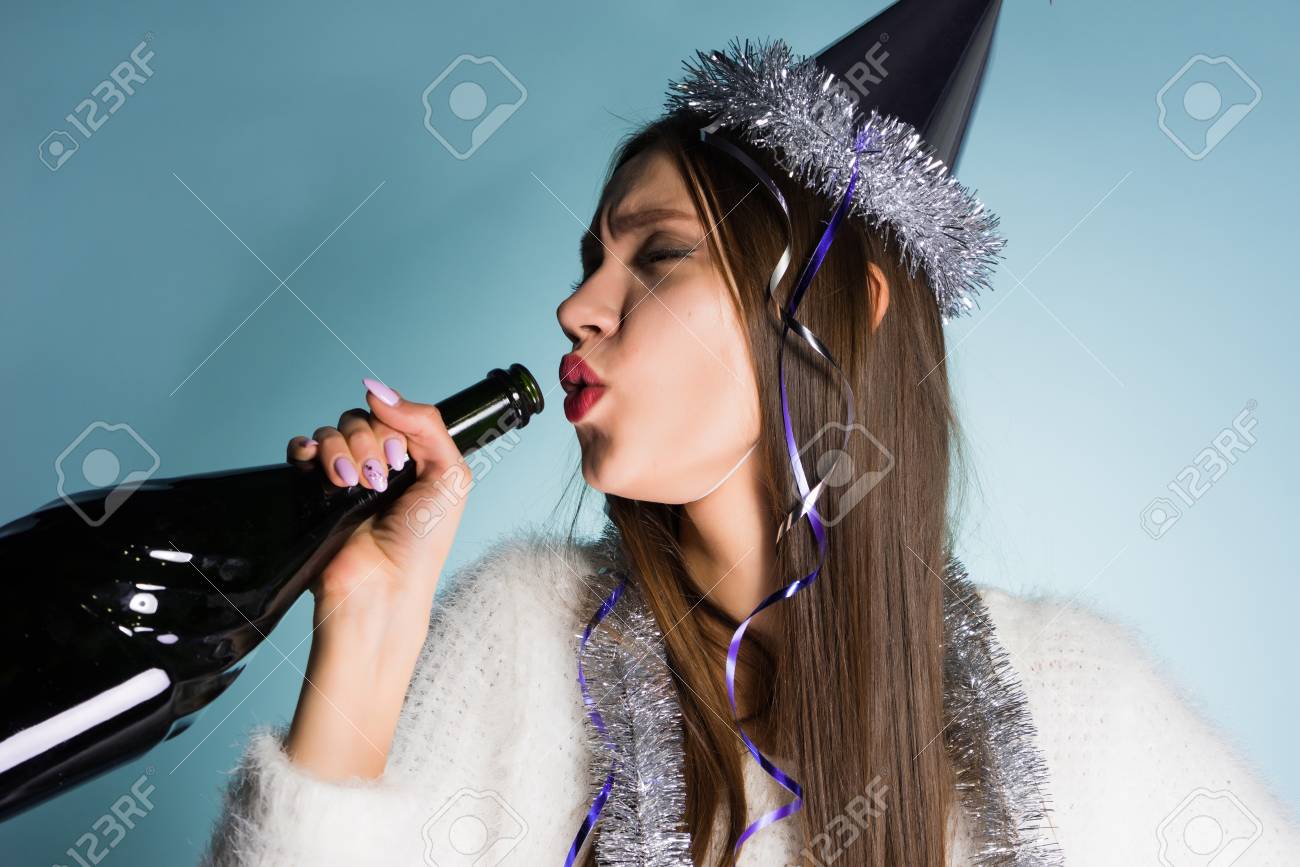 お祝いの帽子をかぶった酔っ払いの女性は 彼女の手にボトルを保持しています の写真素材 画像素材 Image