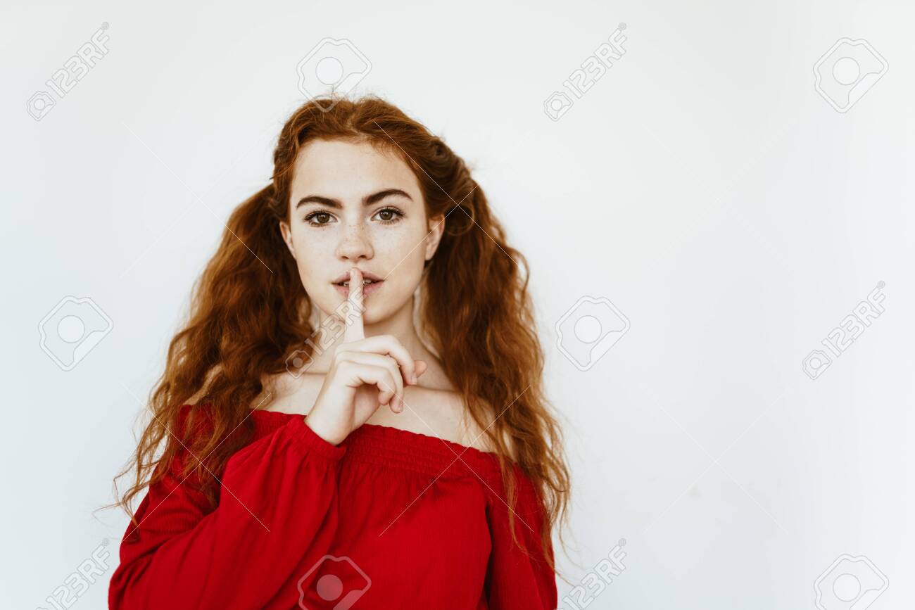 girl with luxurious hair gathered in tails put a finger to her lips, calling for silence - 134082717 girl with luxurious hair gathered in tails put a finger to her lips, calling for silence - 134082717
