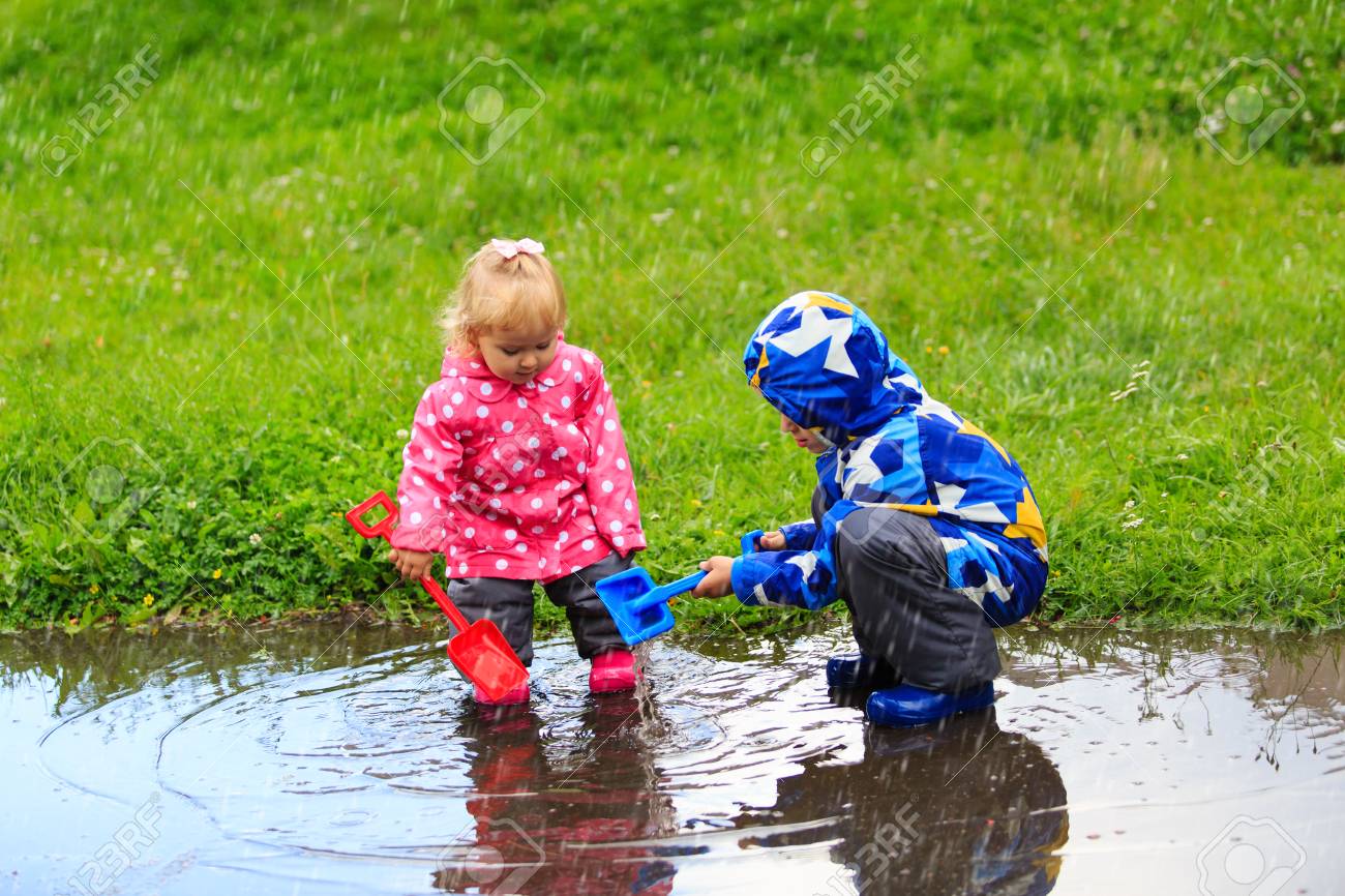 男の子と女の子の雨 屋外の子供の遊びで楽しんで の写真素材 画像素材 Image