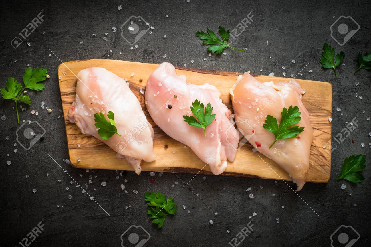 生の鶏肉ササミまな板の上 料理の準備ができて 新鮮な鶏の胸肉のステーキ 黒い石のテーブルの平面図です の写真素材 画像素材 Image