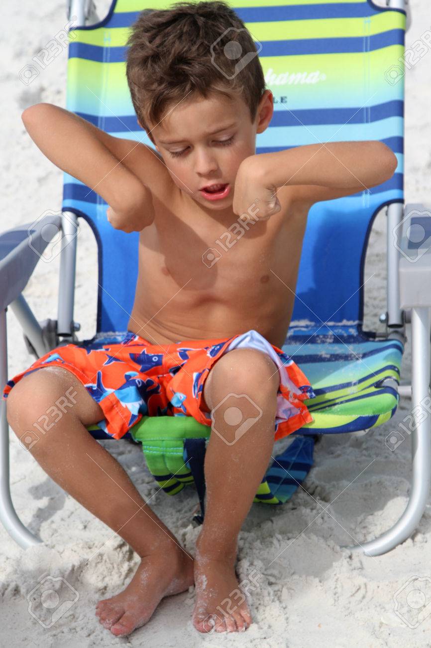 Young Boy Sits On A Sun Chair On A Beach In The Sand And Flexes Stock Photo Picture And Royalty Free Image Image 51624457