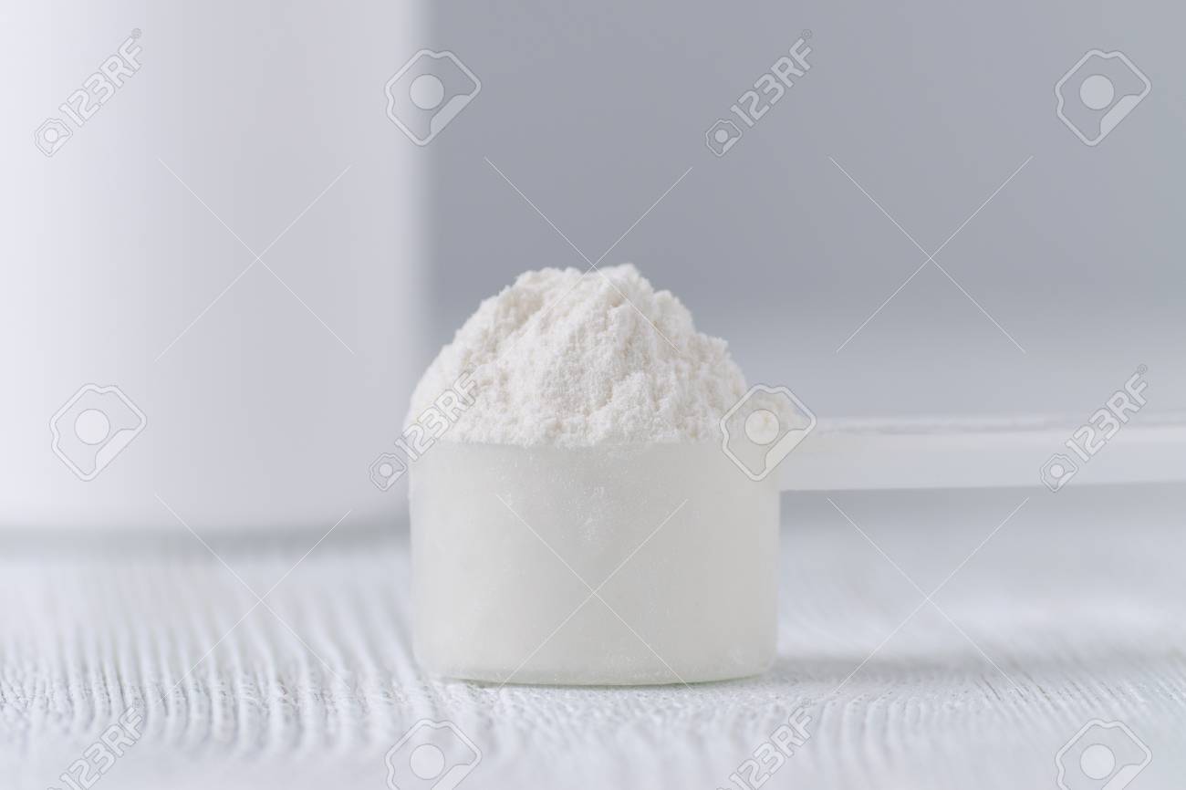 a scoop with white powder closeup and a jar on gray background - 101545952 a scoop with white powder closeup and a jar on gray background - 101545952