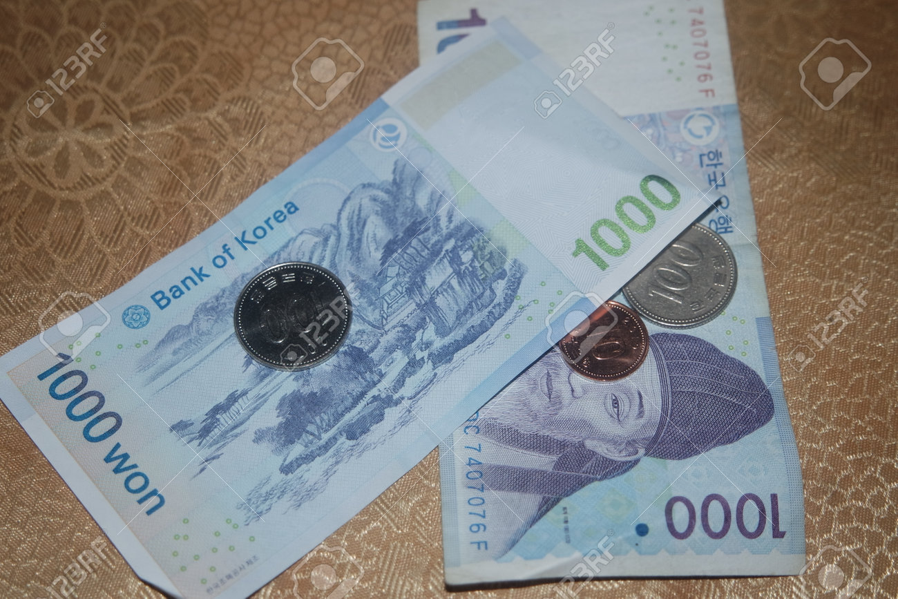 나무 바닥에 있는 한국 지폐 위에 흩어진 은빛 빛나는 한국 원화 로열티 무료 사진, 그림, 이미지 그리고 스톡포토그래피. Image  161410626