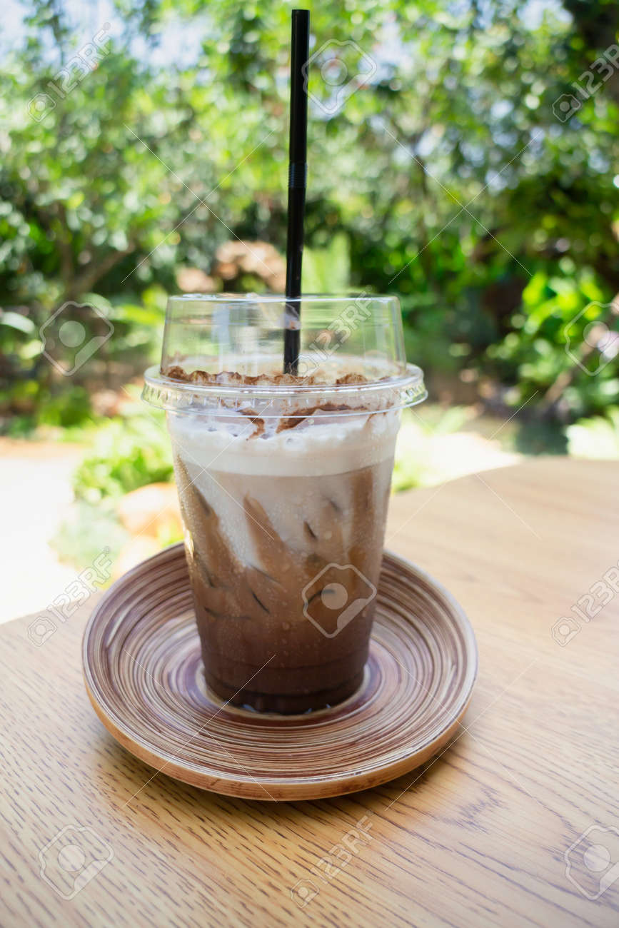 Female hand holding iced coffee drink in disposable take away cup, stock photo - 168400229 Female hand holding iced coffee drink in disposable take away cup, stock photo - 168400229