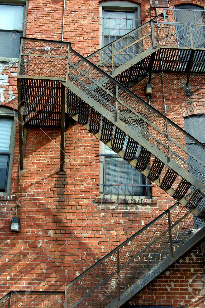 Fire Escape Winds Back And Forth Down The Side Of An Old Brick Apartment Complex In Fire Escape Winds Back And Forth Down The Side Of An Old Brick Apartment Complex In