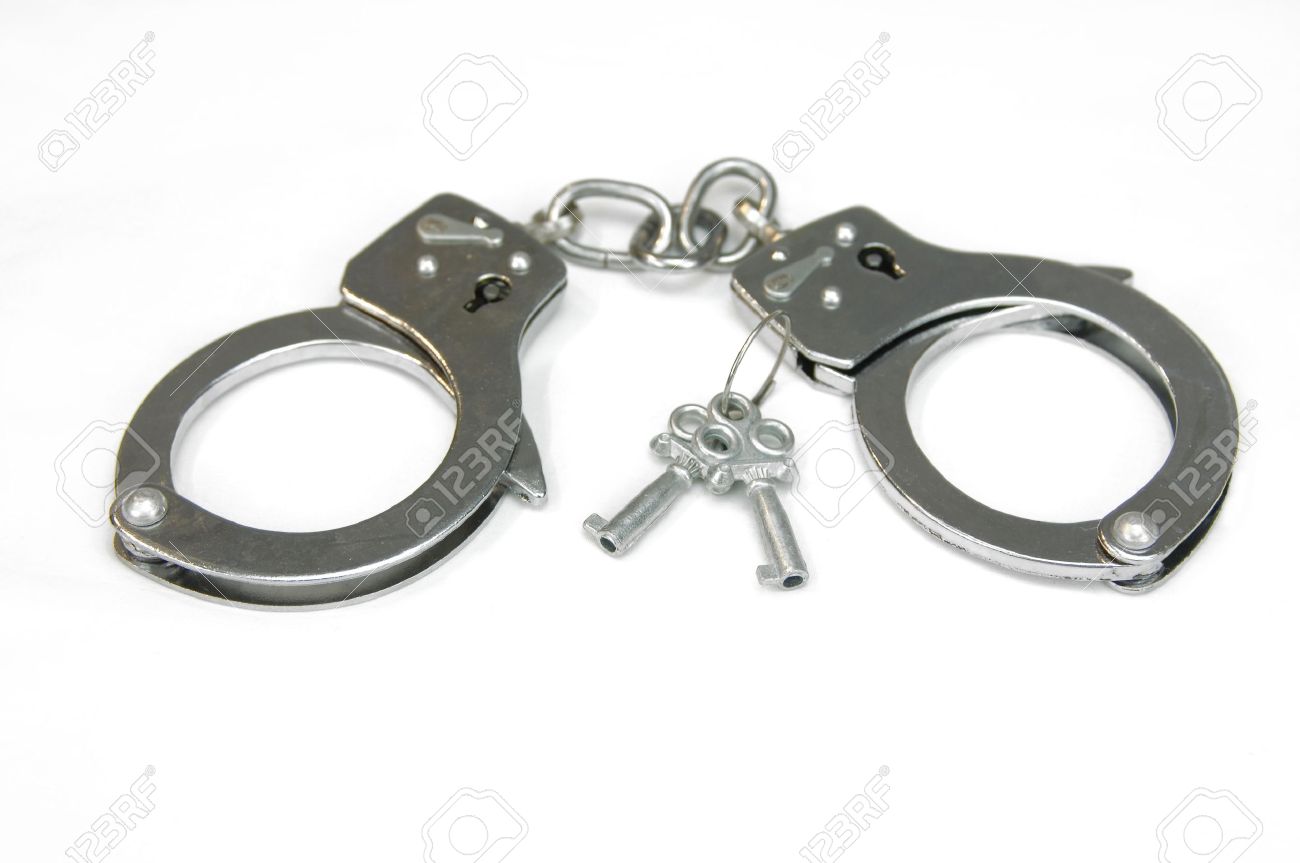 Pair of silver handcuffs lay besides two keys that can unlock them. Cuffs lay on all white surface. - 14863748 Pair of silver handcuffs lay besides two keys that can unlock them. Cuffs lay on all white surface. - 14863748