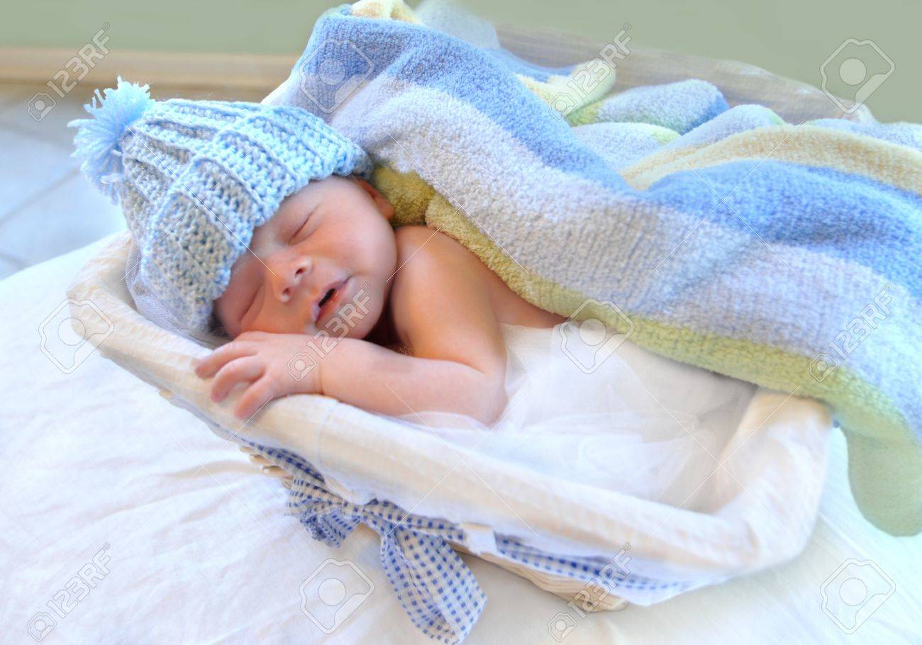 Bebe Dormant Paisiblement Definit Des Dans Un Panier Couvert Par Une Couverture Douce Rayee Il Est Coiffe D Un Bonnet En Tricot Bleu Banque D Images Et Photos Libres De Droits Image