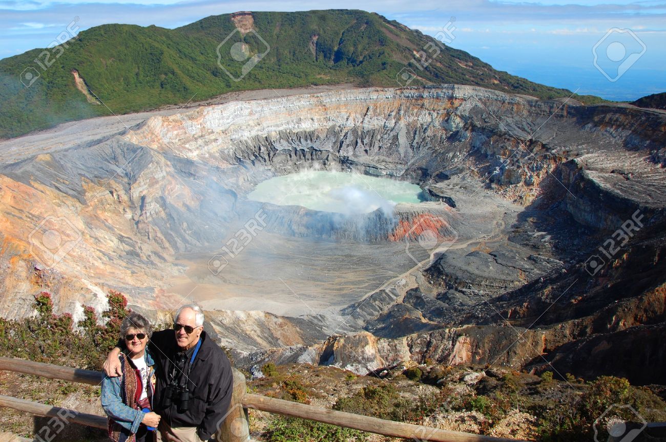 退職させたアメリカのカップルは コスタリカのポアス火山国立公園をご覧ください 火山湖を背景にラグナ カリエンテと呼ばれます 頑丈な火山火口酸性霧を浸透します の写真素材 画像素材 Image