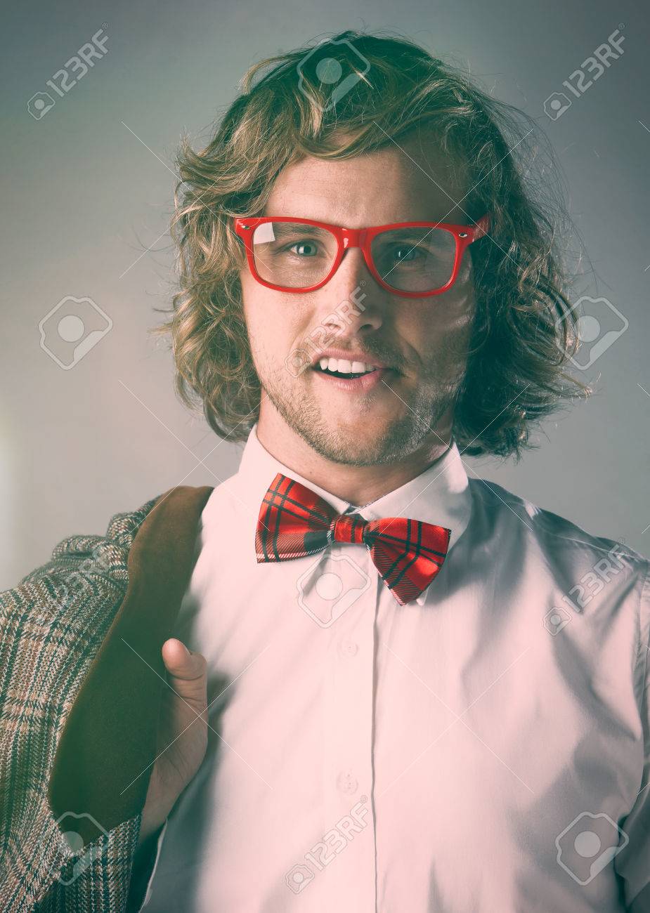 白いを着ているハンサムな白人男性の肖像画はケリ シャツ 赤の市松模様の蝶ネクタイ ファンキーなメガネです 男はポーズと 茶色のジャケットを保持しています の写真素材 画像素材 Image
