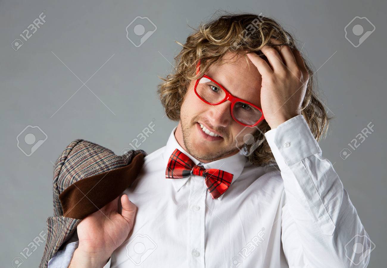 白いを着ているハンサムな白人男性の肖像画はケリ シャツ 赤の市松模様の蝶ネクタイ ファンキーなメガネです 男はポーズと 茶色のジャケットを保持しています の写真素材 画像素材 Image
