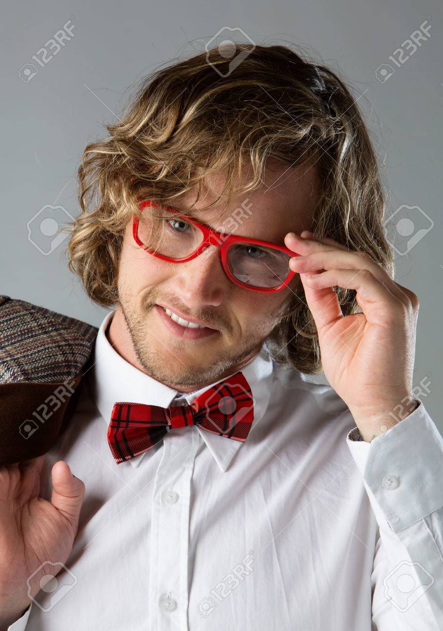 白いを着ているハンサムな白人の男の肖像ケリ シャツ 赤の市松模様の蝶ネクタイ ファンキーな眼鏡 男はポーズと茶色のジャケットを保持しています の写真素材 画像素材 Image
