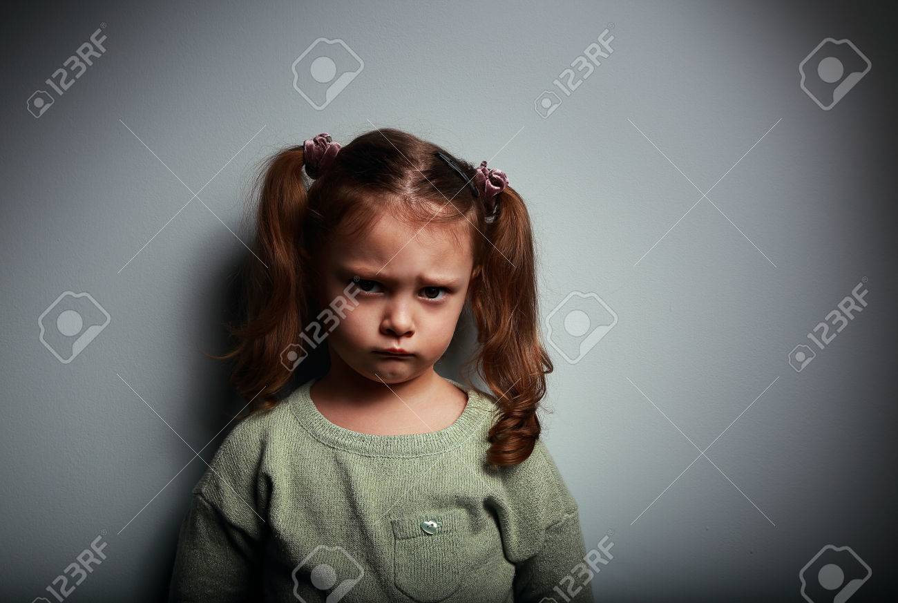 暗い背景に非常に不幸な顔を見て悲しい子供の女の子 の写真素材 画像素材 Image