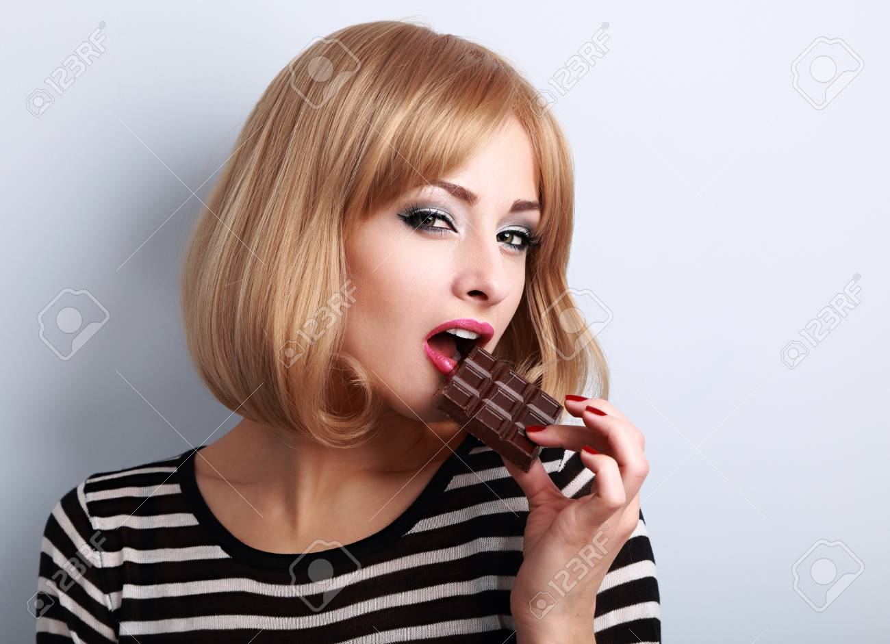 化粧女性セクシーな表情でダーク チョコレートをかみます 短い髪型の女の子とおいしいデザート ポートレート クローズ アップ の写真素材 画像素材 Image