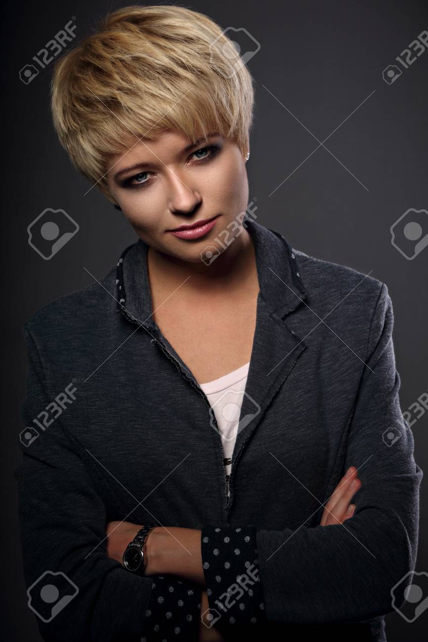 灰色の背景にスーツに金髪ボブが短い髪型と美しい深刻なビジネス女性 ポートレート クローズ アップ の写真素材 画像素材 Image