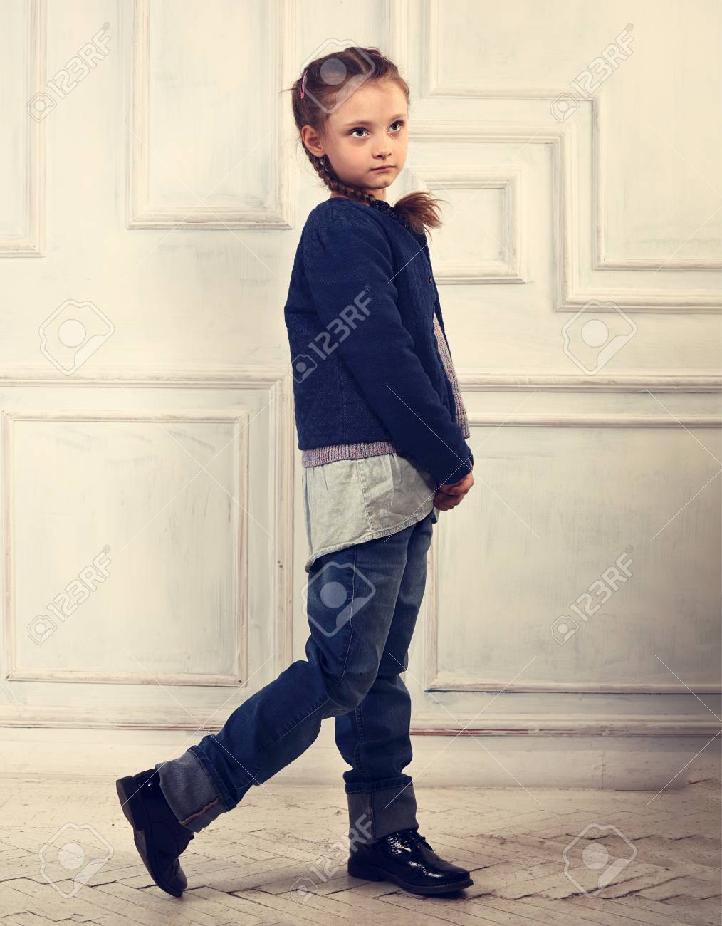 Diversión Feliz Niña Sonriente Niño Posando En Jeans De Blusa, Botas Negras Y Chaqueta Sobre De Estudio. Retrato De Cuerpo Entero. Retrato Fotos, Retratos, Imágenes Y Fotografía Archivo
