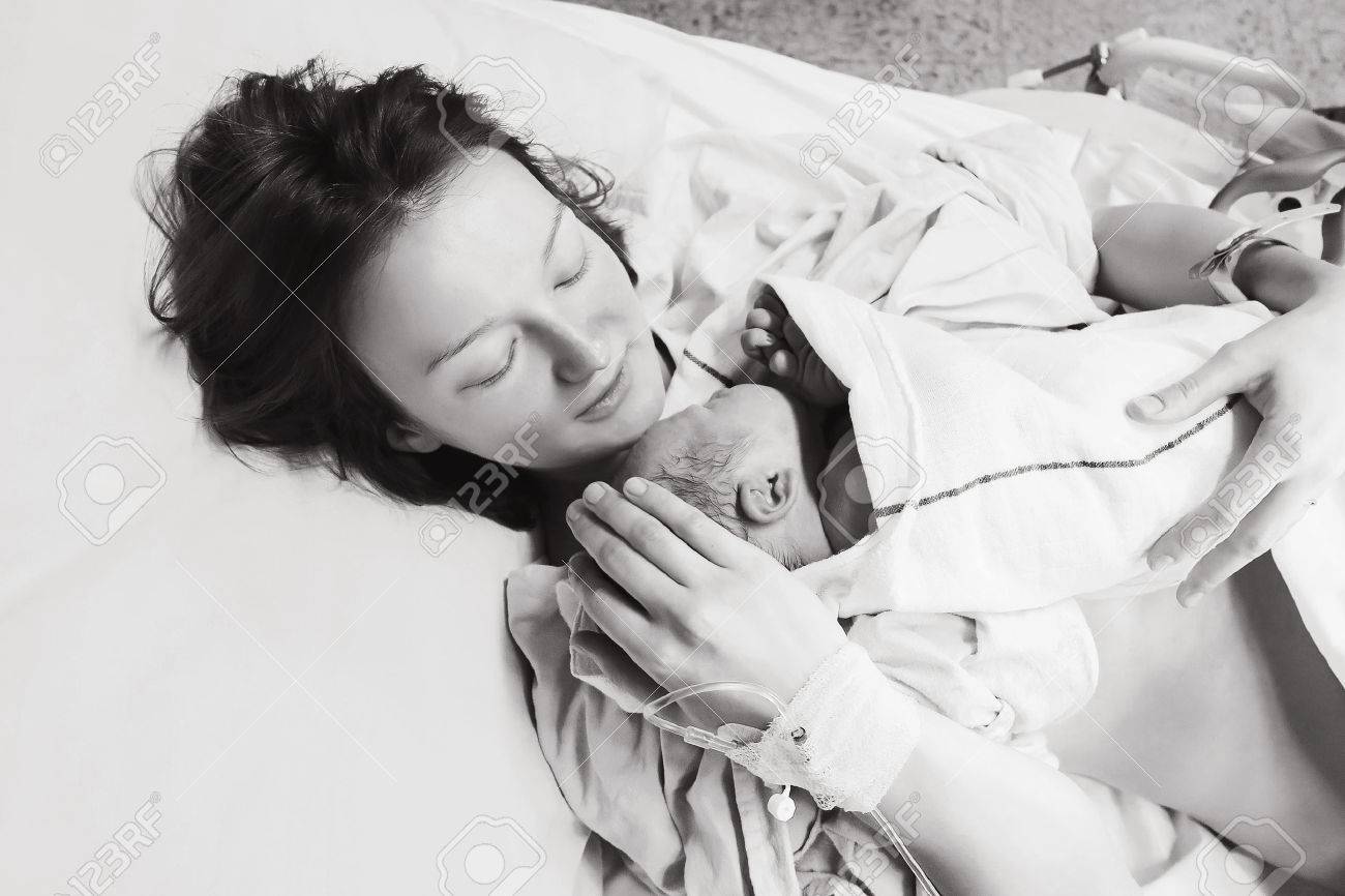 Mother holding her newborn baby child after labor in a hospital. Black and white photo. Parent and infant first moments of bonding. - 72960715 Mother holding her newborn baby child after labor in a hospital. Black and white photo. Parent and infant first moments of bonding. - 72960715