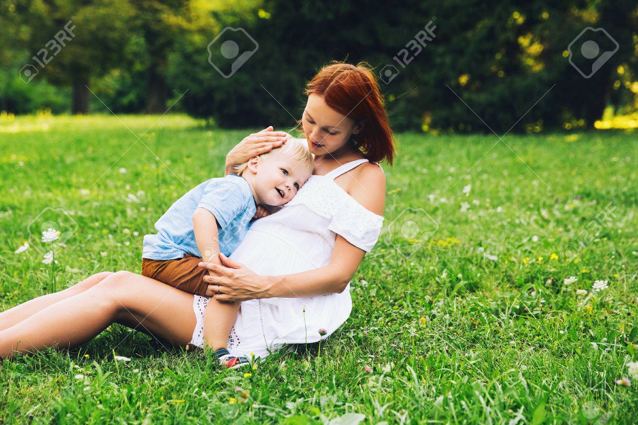 Pregnant woman with toddler kid outdoors. Mother and her son on nature in summer park. Little child boy hugging mother, who pregnant for second time. Pregnancy, new life, family, birth concept. - 83755628 Pregnant woman with toddler kid outdoors. Mother and her son on nature in summer park. Little child boy hugging mother, who pregnant for second time. Pregnancy, new life, family, birth concept. - 83755628