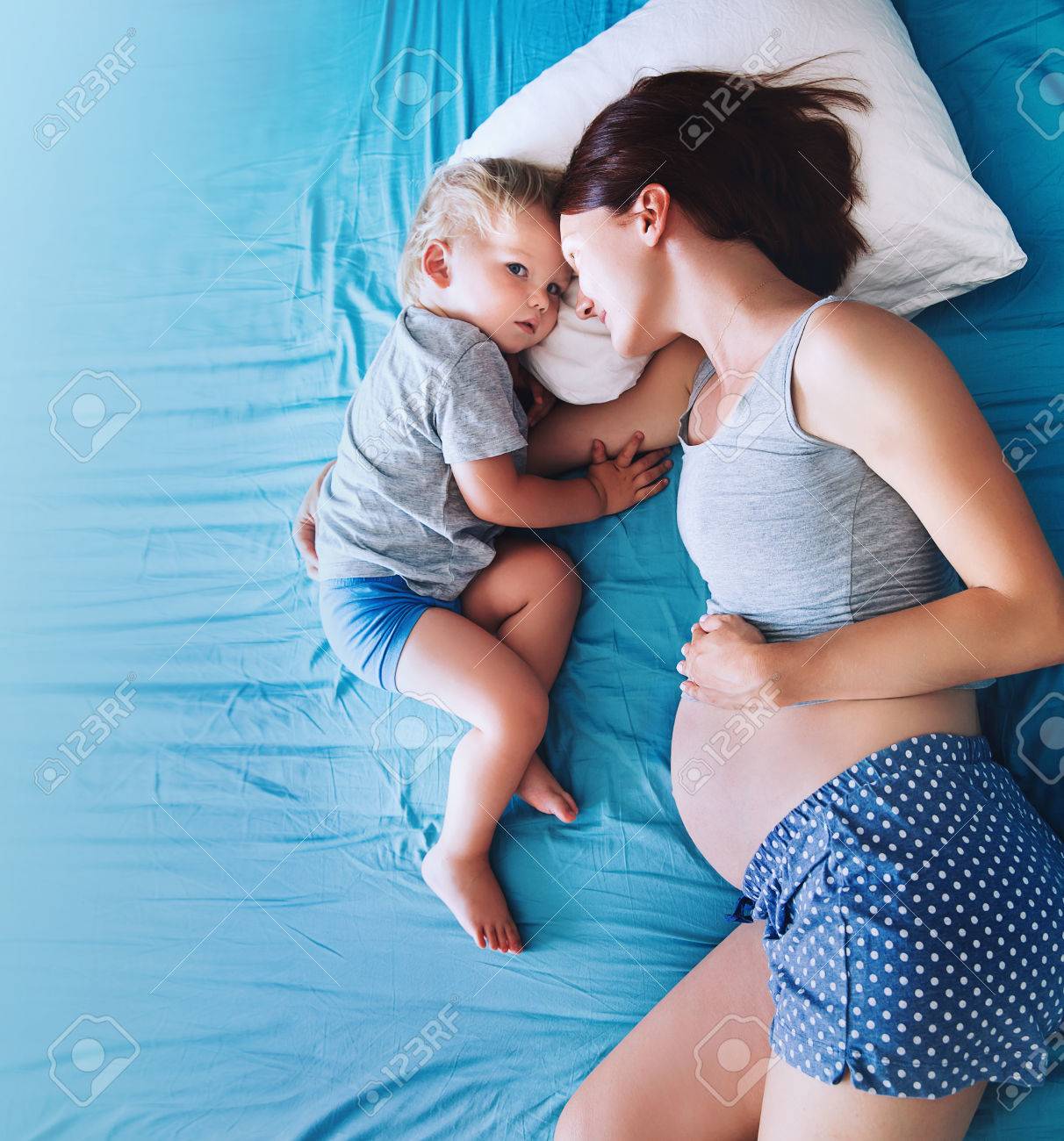 Pregnant mother and son laying in bed at home. Pregnant for second time with first child. Toddler boy and mom. Family in expectation of baby. Pregnancy, family, love, maternity concepts. - 84179253 Pregnant mother and son laying in bed at home. Pregnant for second time with first child. Toddler boy and mom. Family in expectation of baby. Pregnancy, family, love, maternity concepts. - 84179253