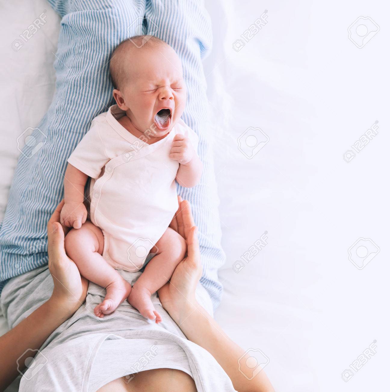 Newborn baby girl sleeps and yawning. Sleeping new born little child in the hands of his mother. Image of happy maternity and baby care. - 86260579 Newborn baby girl sleeps and yawning. Sleeping new born little child in the hands of his mother. Image of happy maternity and baby care. - 86260579