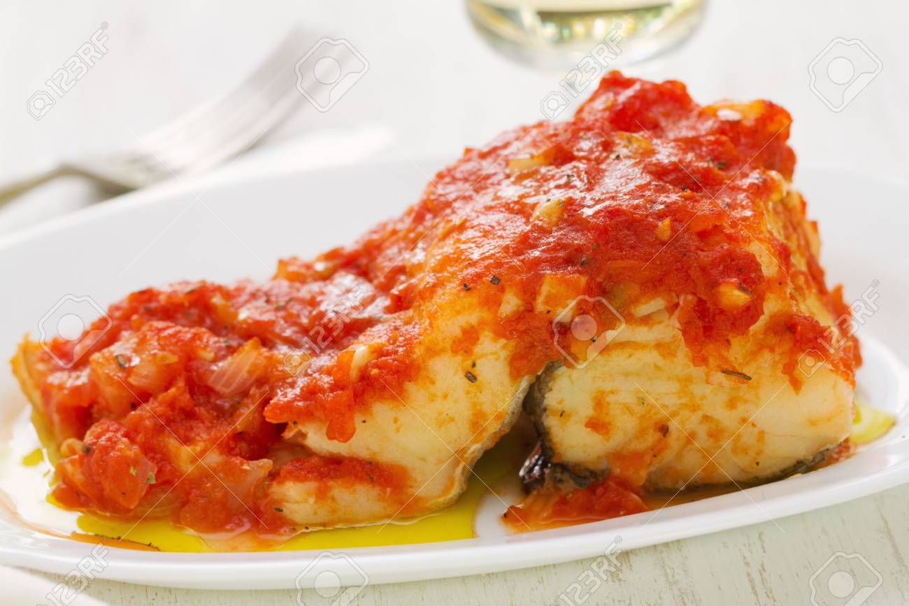 Cod Fish With Tomato Sauce On White Dish And Glass Of White Wine Stock Photo Picture And Royalty Free Image Image 59181746