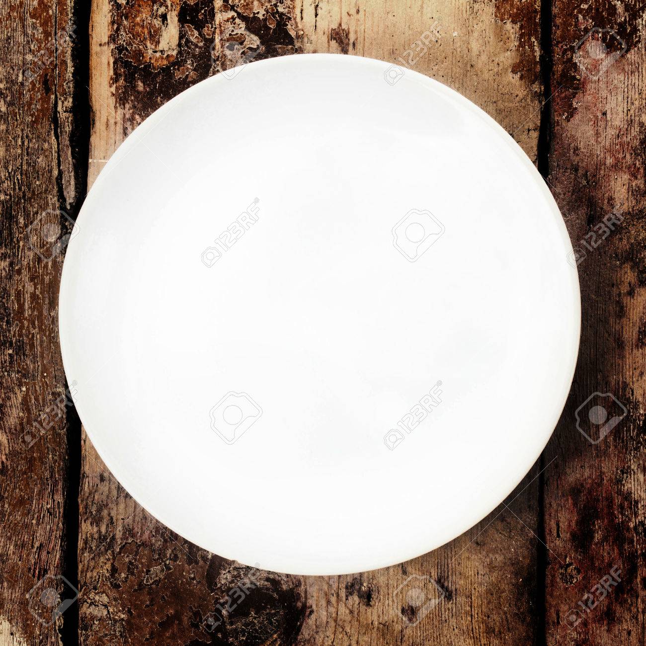 White Plate On Wooden Old Table, Top Shot Stock Photo, Picture and Royalty  Free Image. Image 23875926.