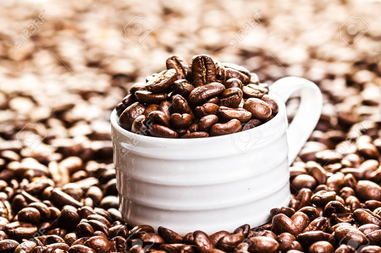 White Coffee Cup With Roasted Coffee Beans On Heap Of Coffee Stock Photo Picture And Royalty Free Image Image 25774071