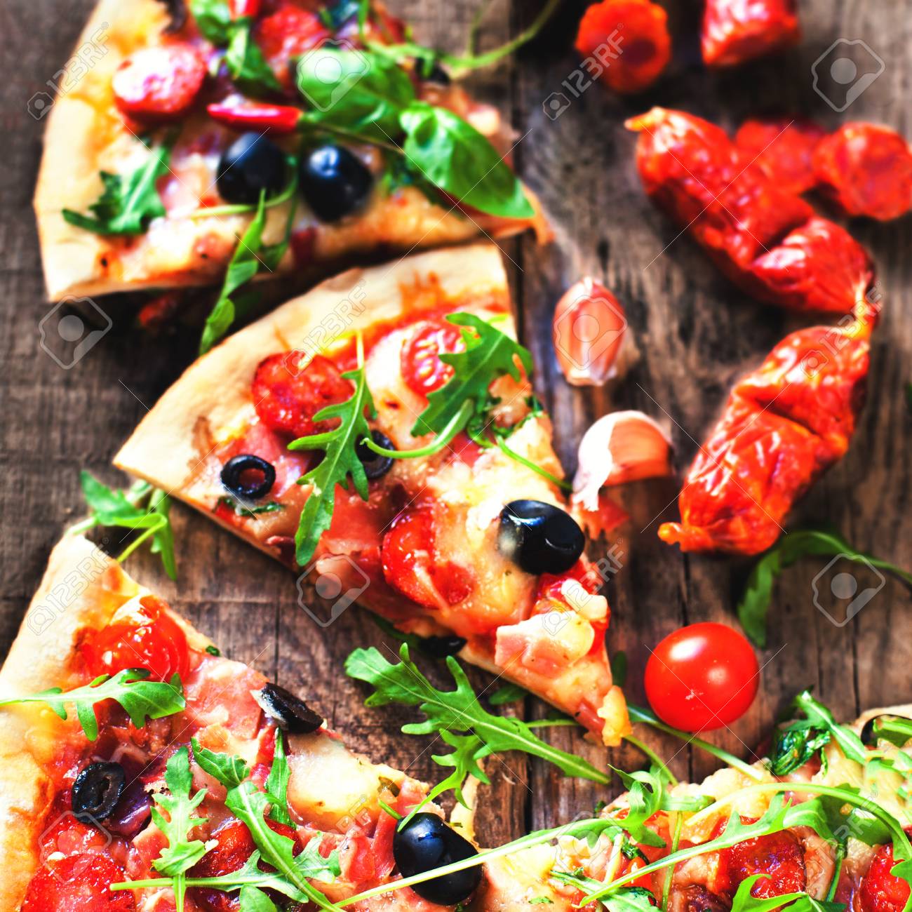 ペパロニ 素朴な木製のテーブルの上のチーズを溶かすとホットのピザのスライスをクローズ アップ の写真素材 画像素材 Image